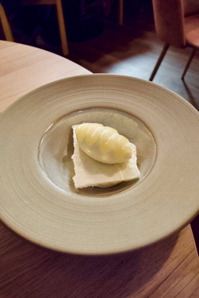 Glace au panais surmonté d'un gel gingembre et poire dans une assiette creuse en grès blanc cassé