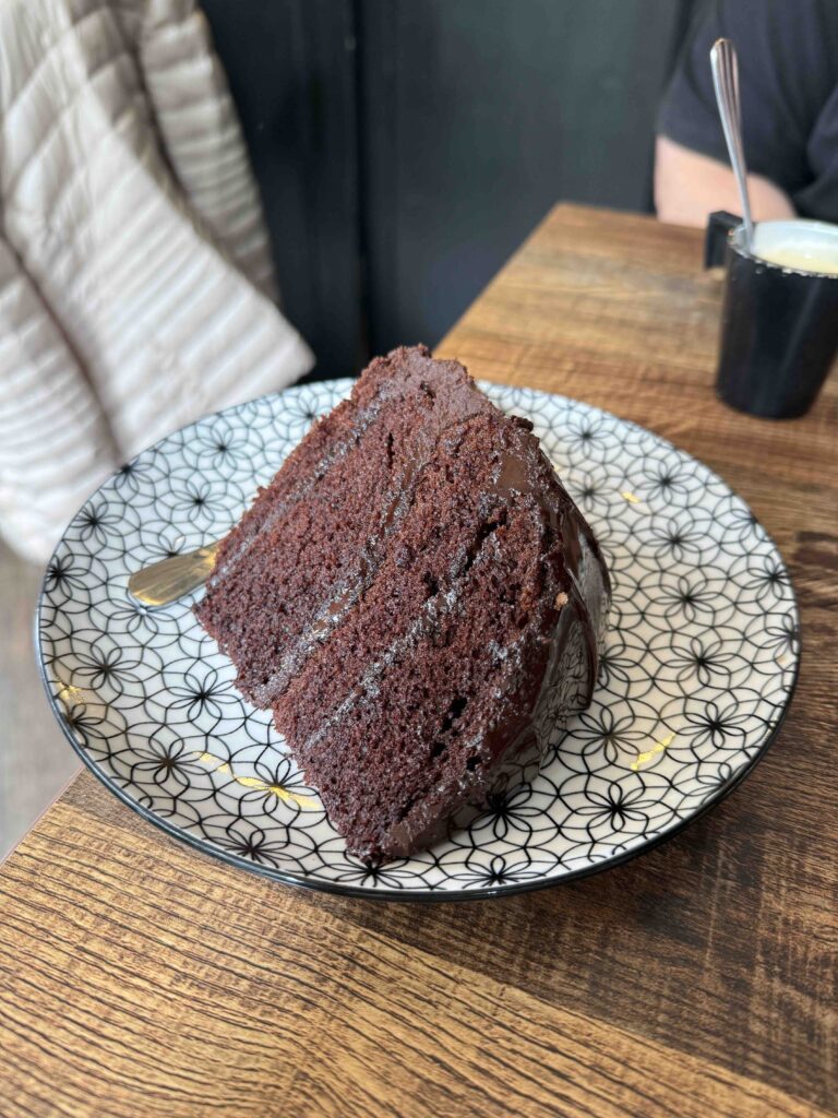 Part de gâteau au chocolat dans une assiette ronde à motifs floraux géométriques