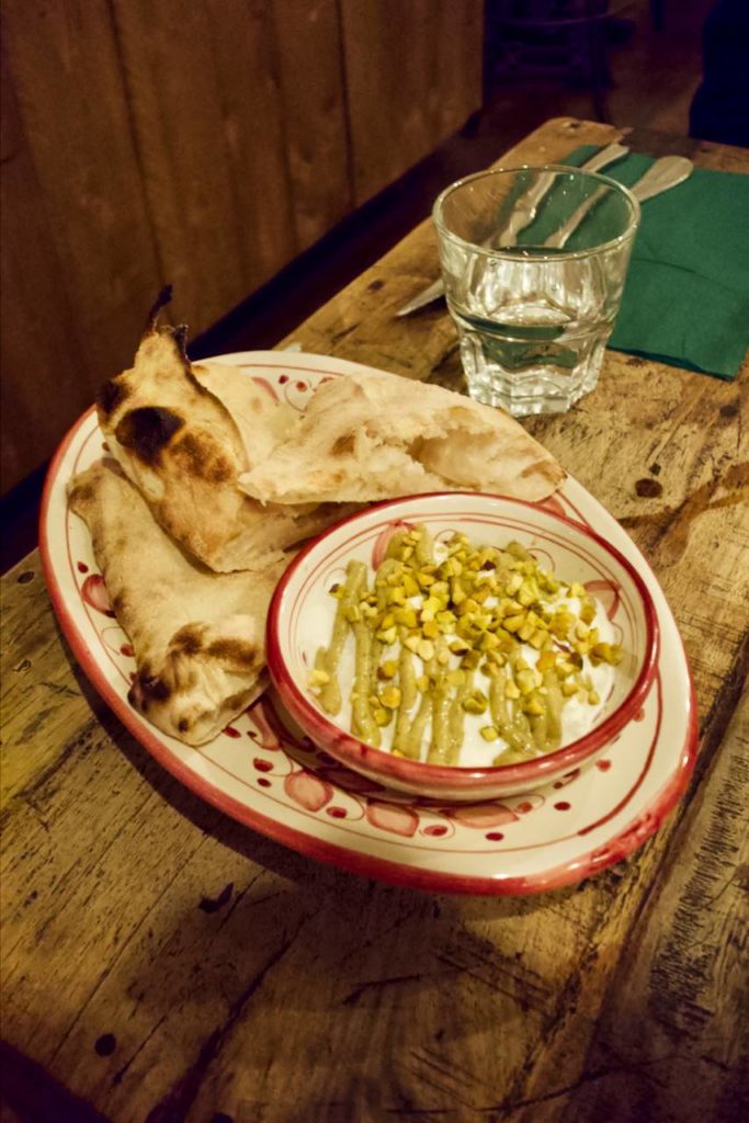 burrata à la pistache accompagnée de pâte à pizza dans une vaisselle vintage
