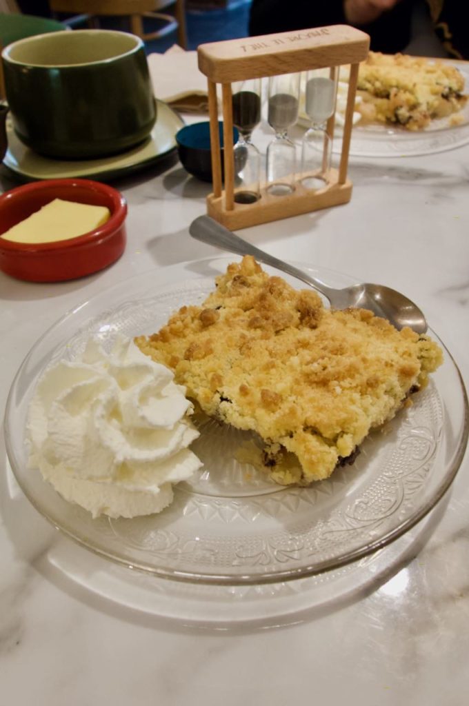Crumble pommes, poires et chocolat, chantilly, dans une assiette en verre