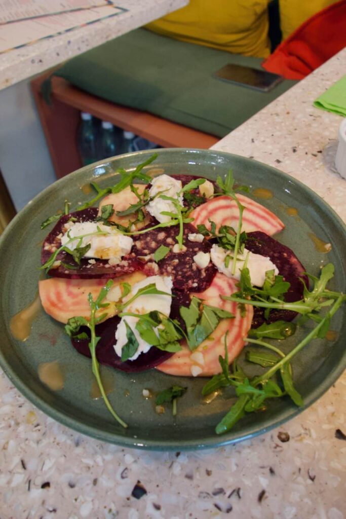 Carpaccio de betterave au chèvre dans une assiette en grès verte