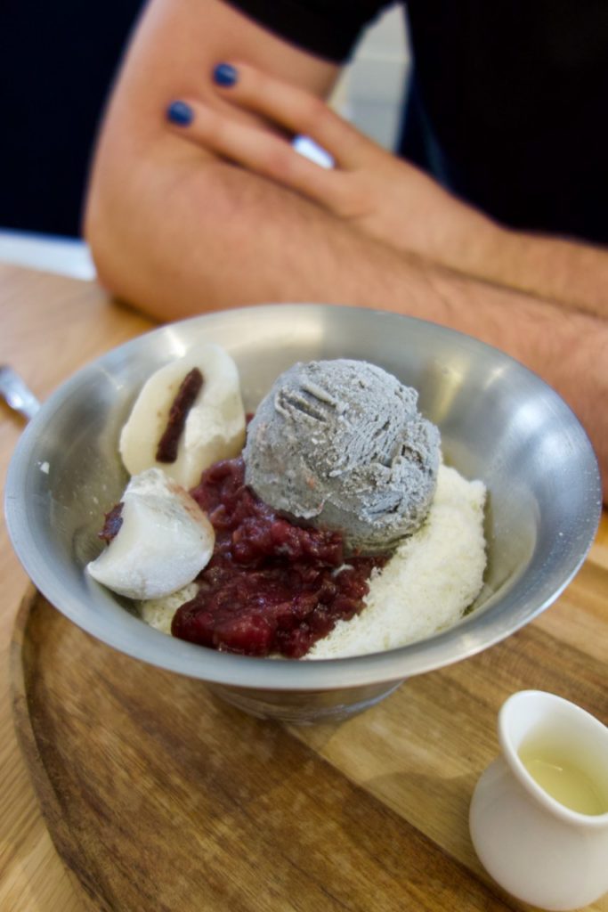 bingsu haricot rouge, glace sésame noir, mochi dans un bol en fer