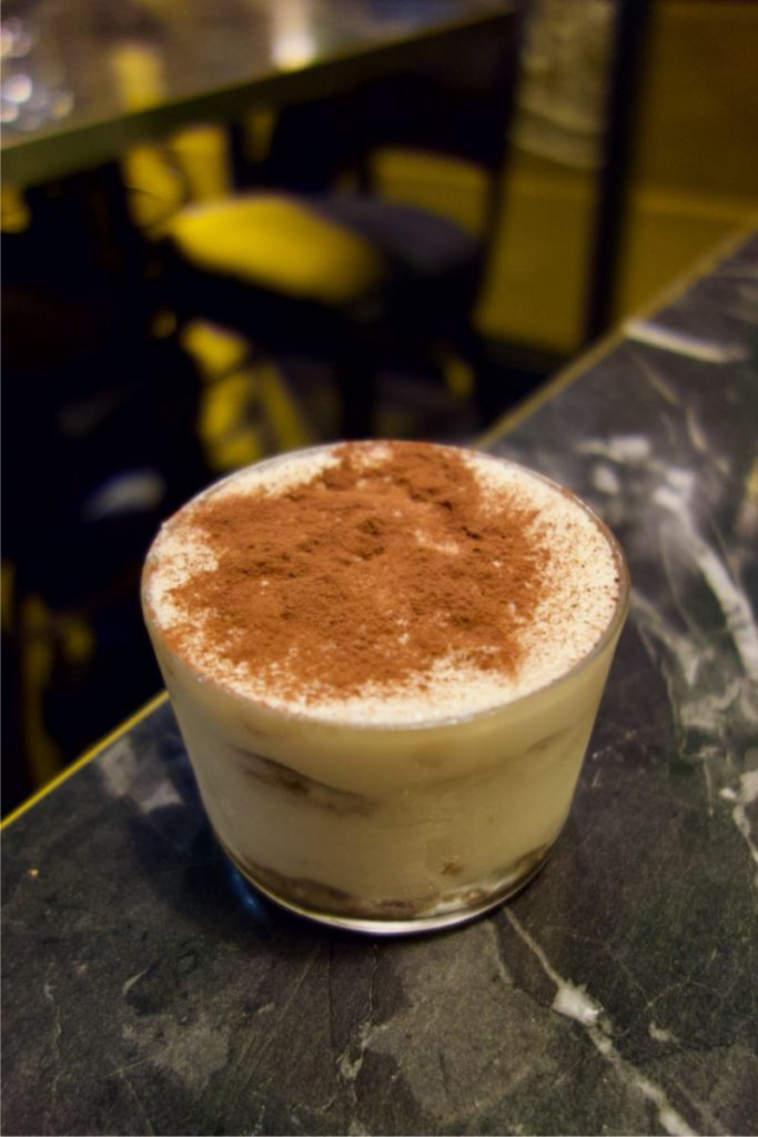 Tiramisu dans un verre transparent sur une table style marbre