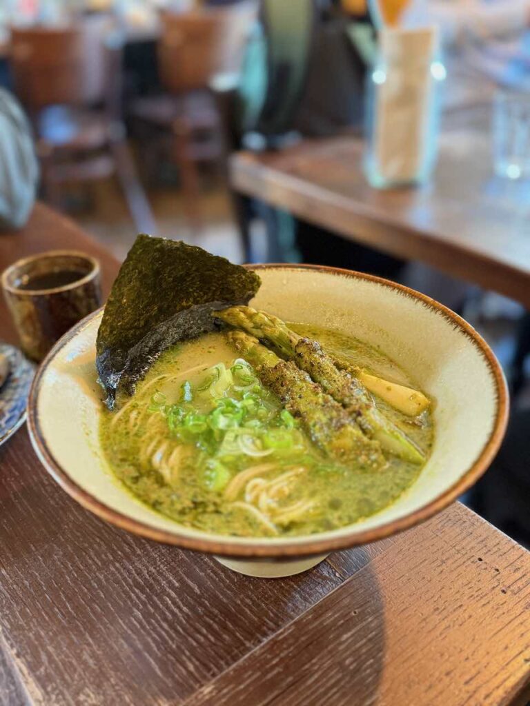 Ramen avec asperges, algue nori et cébette dans un bol en grès blanc et liseré marron