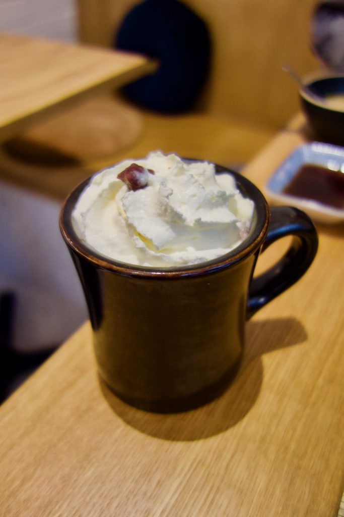 red bean latte surmonté de chantilly dans une tasse noire