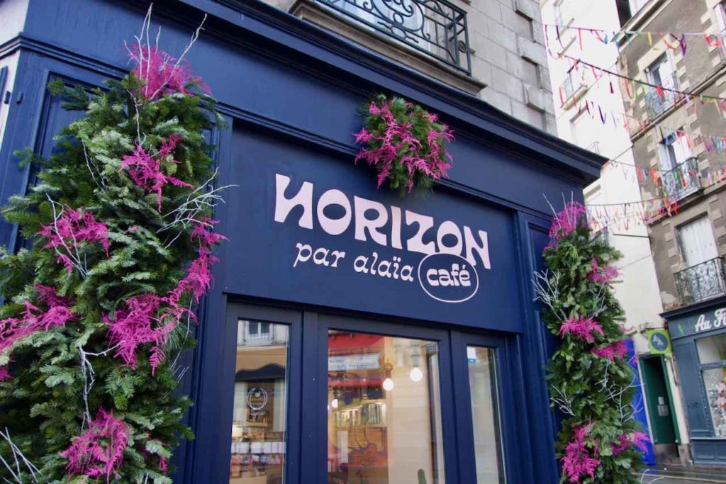 devanture bleue de Horizon Café entourée de fleurs