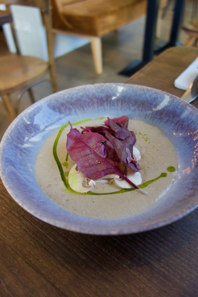 Velouté de champignons dans une assiette bleu émaillée