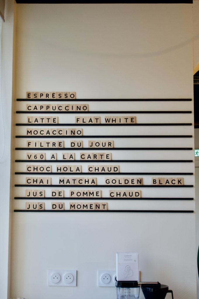 Carte des boissons au mur faite de lettres en bois et typo noire