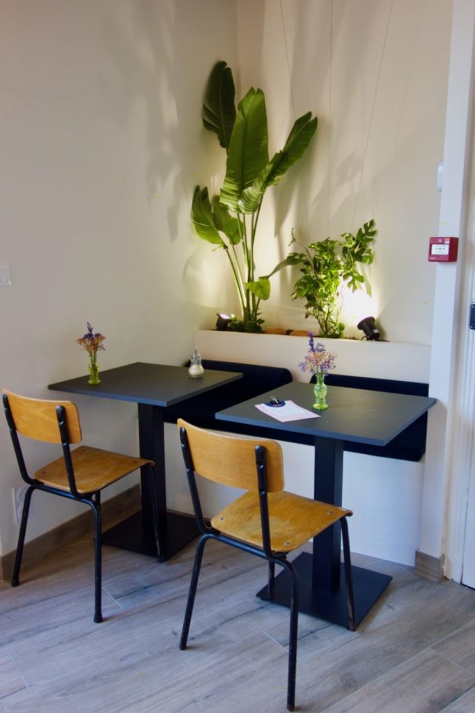 Deux tables et chaises devant une vasque pourvue de plantes