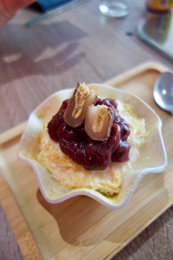 Bingsu au haricot rouge dans un bol blanc et sur un petit plateau en bois