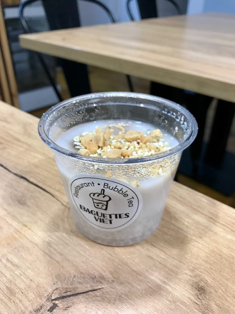 Banane au lait de coco dans un récipient en plastique transparent sur une table en bois