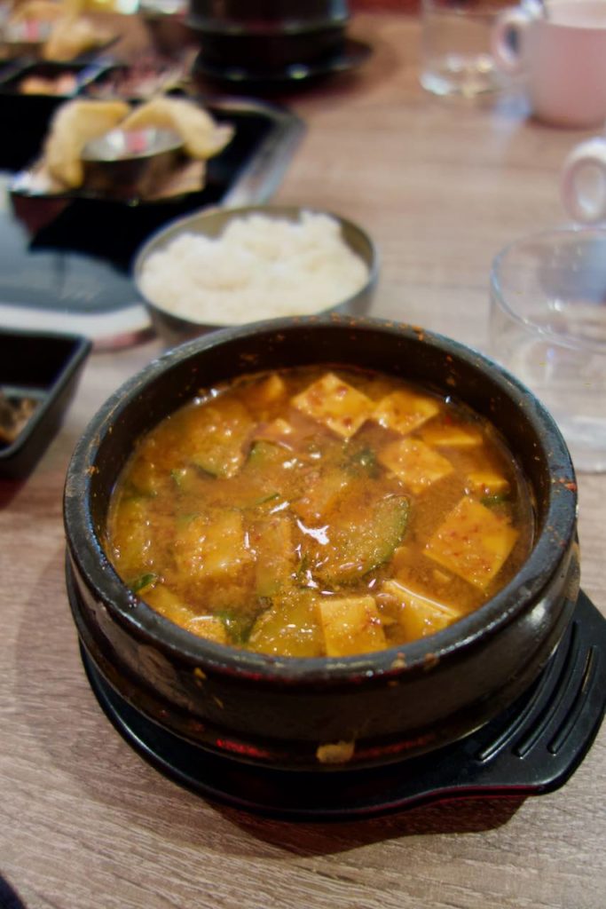 Tofu et légumes dans une cassolette noire sur une table en bois