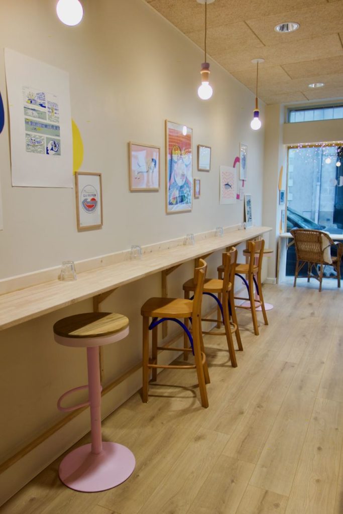 Longue table en bois et chaises hautes en bois contre un mur blanc