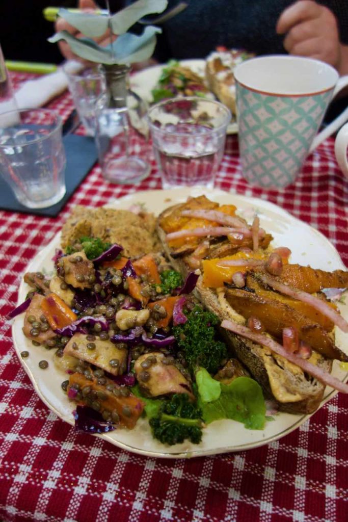 Assiette de légumes rôtis et tartine sur une nappe à carreaux