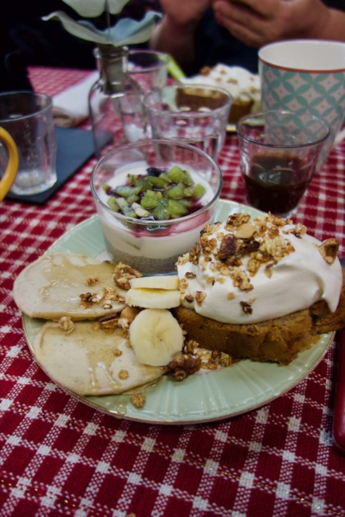 Assiette de pancakes, gâteau et verrine sur une table à nappe à carreaux rouges et blancs
