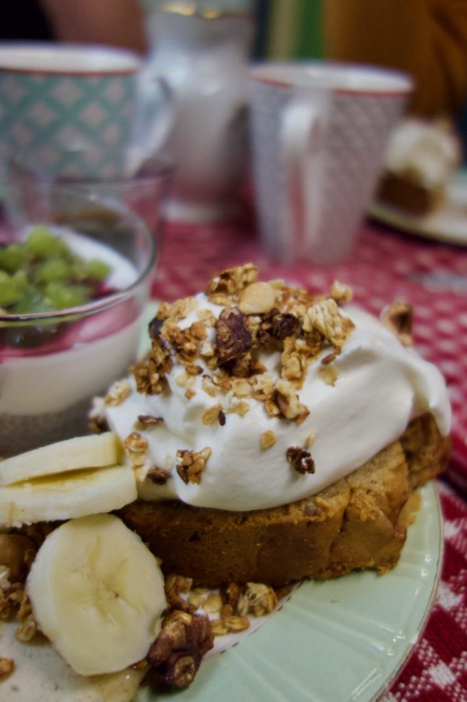 Gros plan sur le banana bread surmonté de crème et de granola