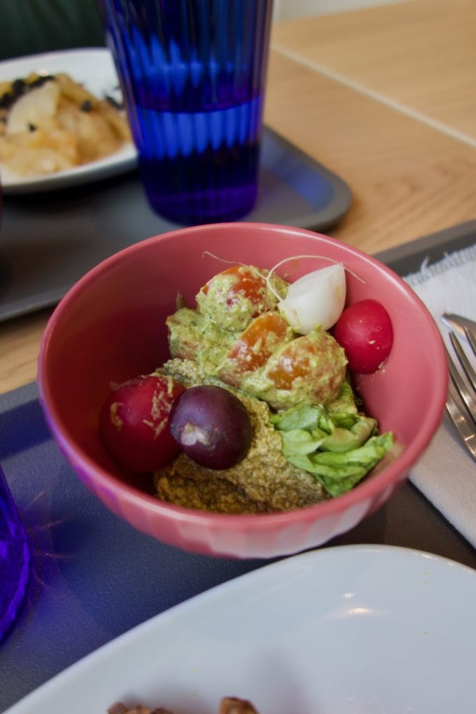 Tomates cerise et pesto dans un bol rose sur un plateau bleu