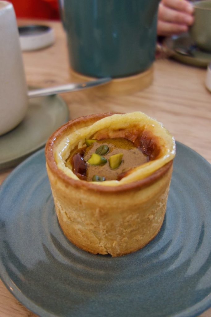 Flan au coeur praliné pistache dans une assiette bleue