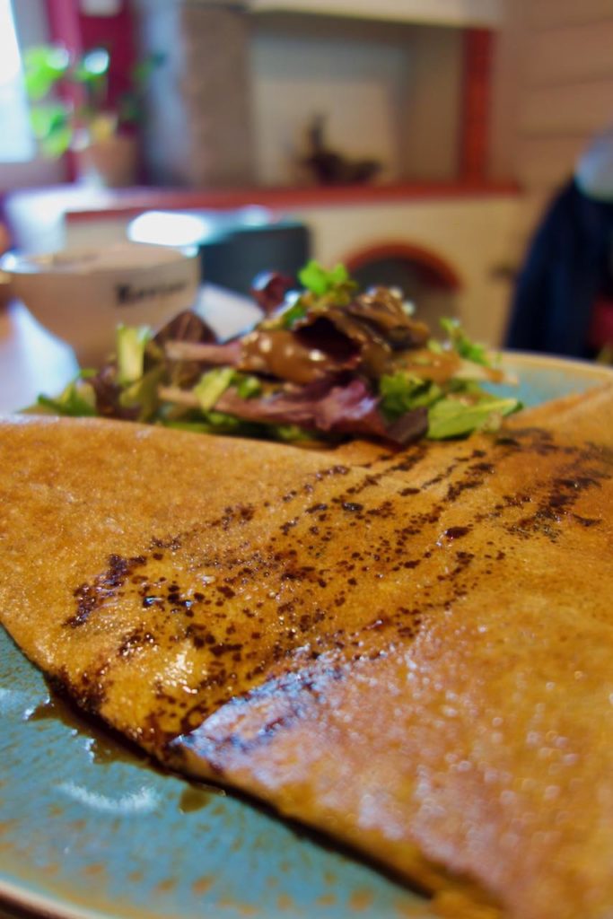 Galette de sarrasin avec sa salade dans une assiette bleue