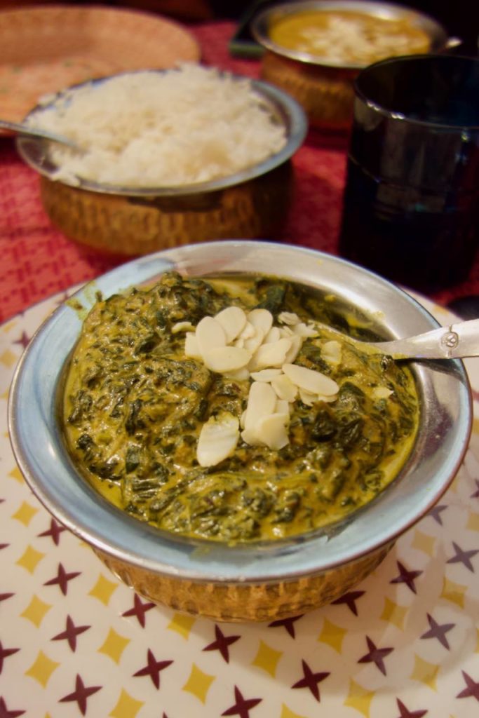 Palak panir dans un bol en acier et cuivre sur une assiette à motifs étoiles