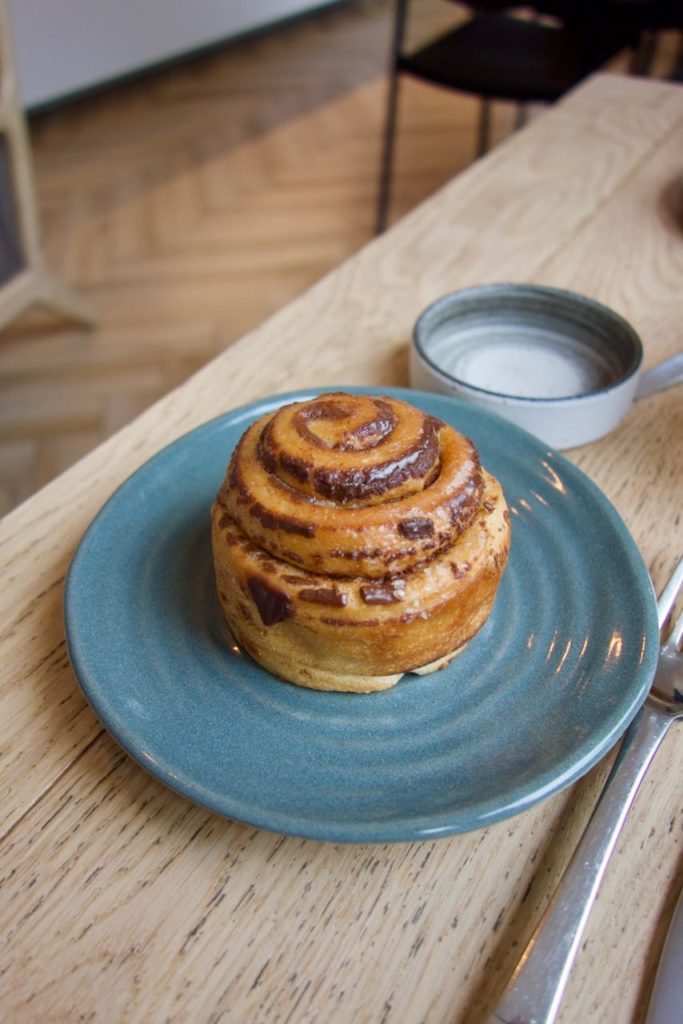 kanelbullar dans une assiette bleue en terre cuite sur une table en bois