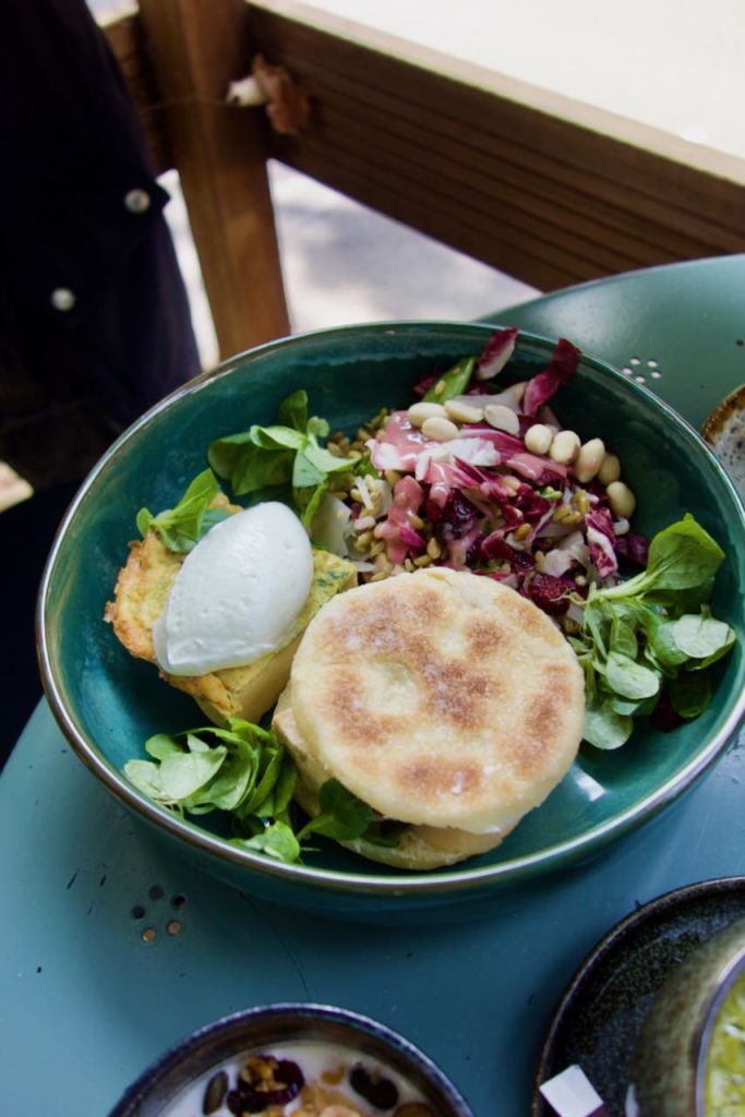Assiette salée composée d'un muffin, d'un clafoutis et d'une salade posée sur une table bleue en métal