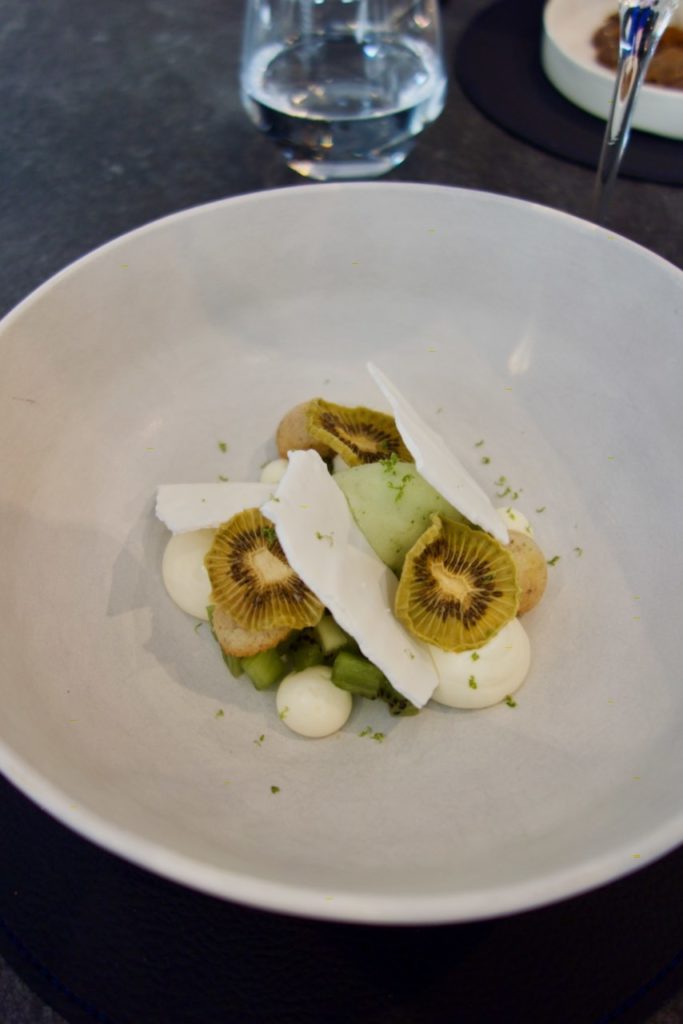 Kiwi déshydraté, meringue et glace citron/menthe dans une grande assiette blanche