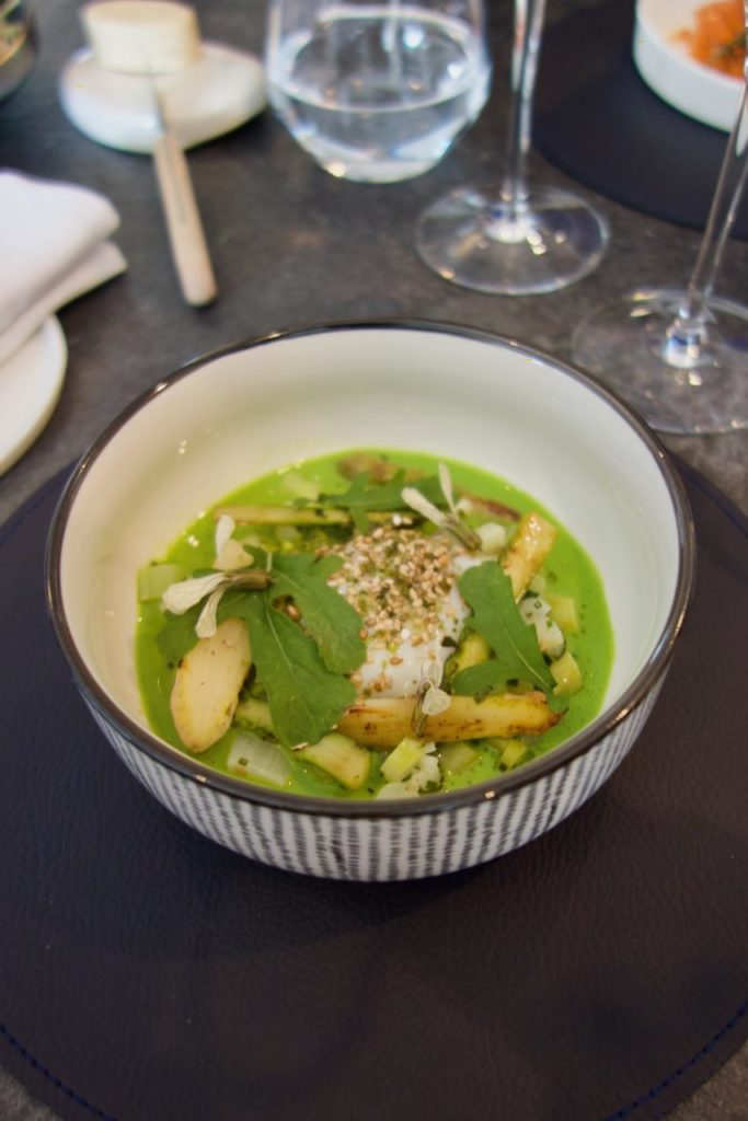Asperges et sauce curry vert dans un bol blanc à rayures grises