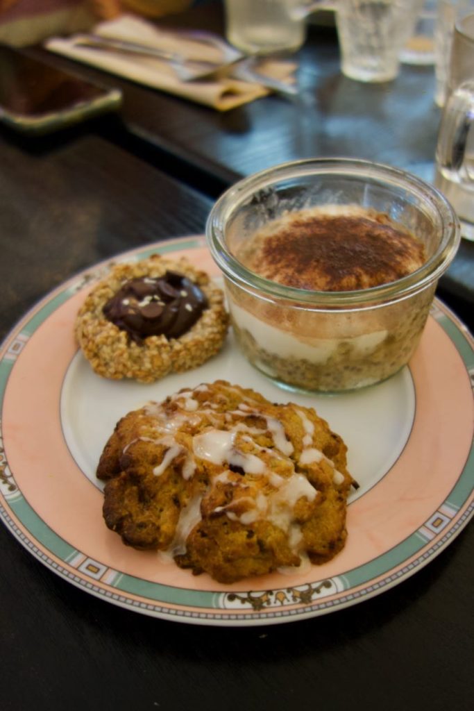 Porridge dans un bocal en verre, nid de banane et carrot cake sur une assiette vintage vieux rose et vert de gris