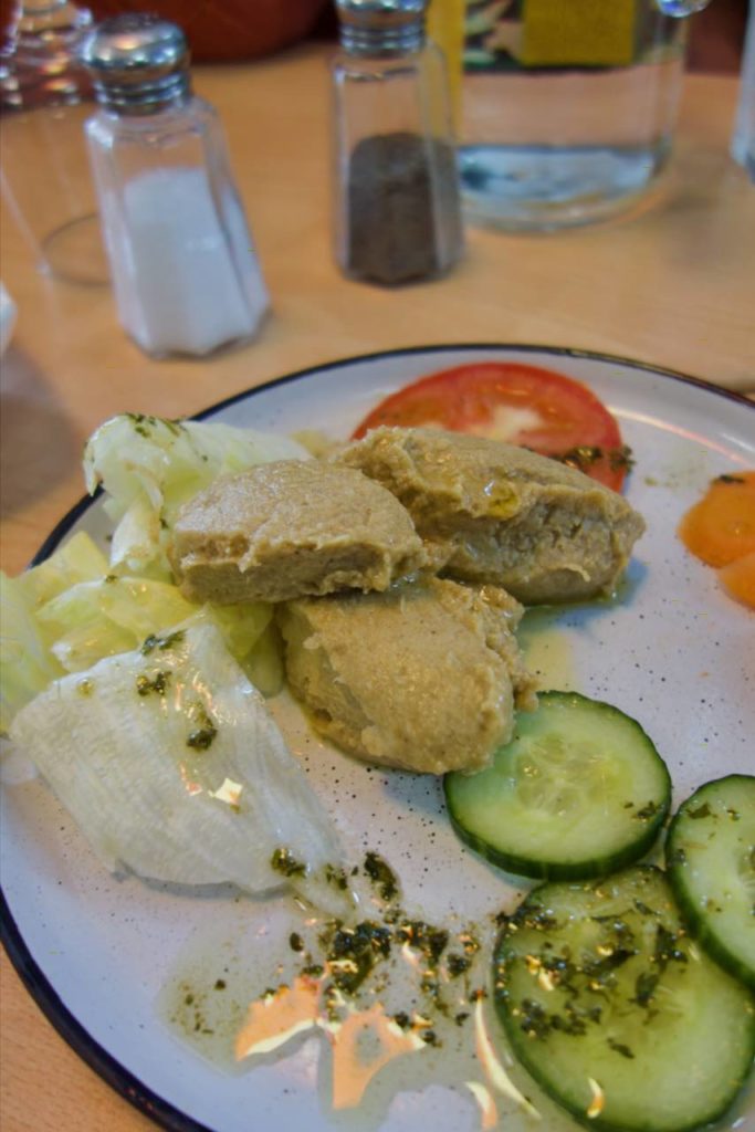 Houmous, concombre, tomate et salade dans une assiette blanche
