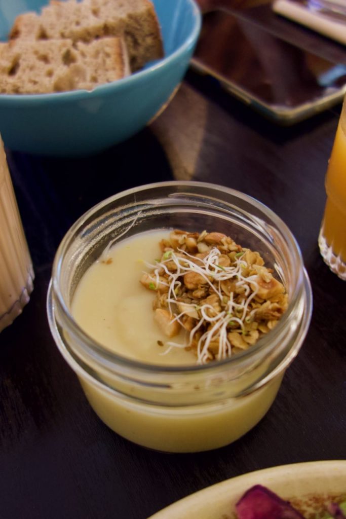 Velouté surmonté de granola et jeunes pousses dans un bocal en verre