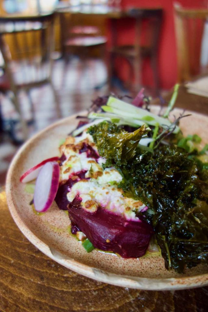 Gros plan sur les betteraves surmontées de feta rôtie et sur le kale frit