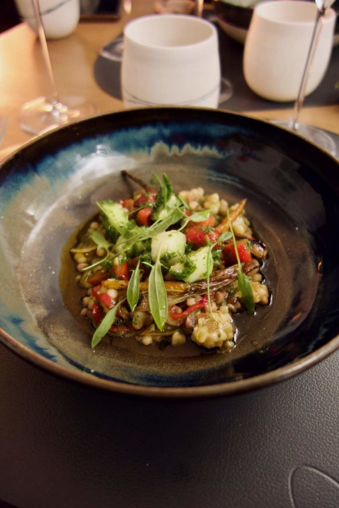 Fregola sarda, navet et herbes dans une assiette creuse noire et bleue