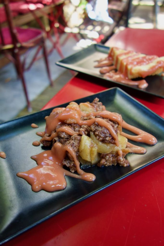 Crumble aux pommes dans une assiette noire allongée