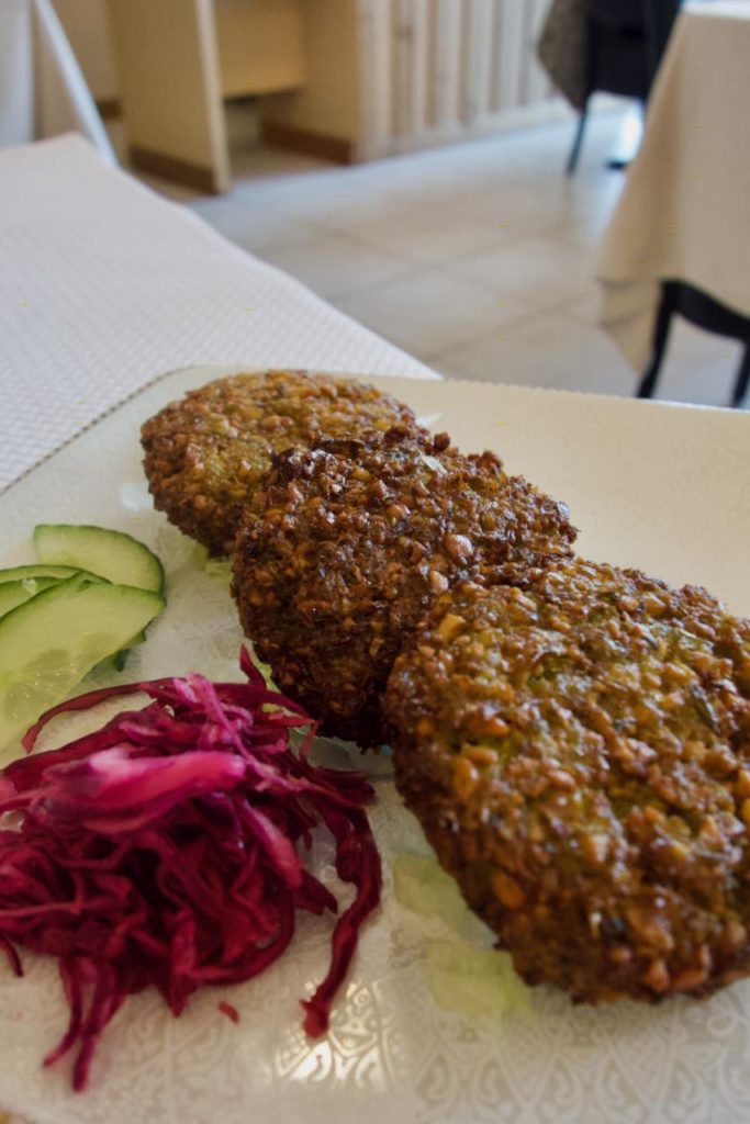 Trois falafels plats accompagnés de chou râpé et de concombre