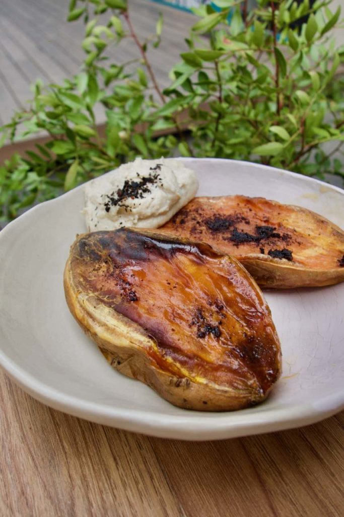 Patates douces rôties, sauce tahini dans une assiette en grès