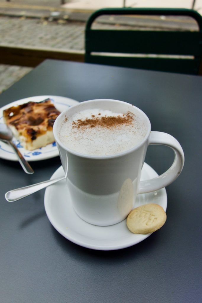 chaï latte dans une tasse blanche accompagné d'un petit gâteau au beurre
