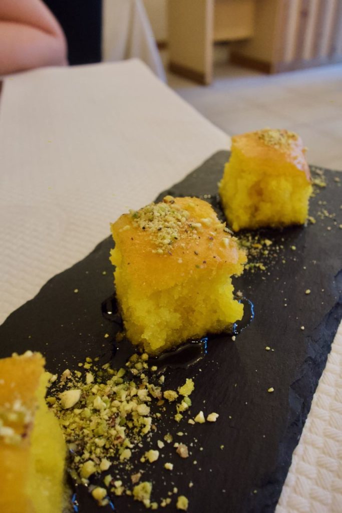 Trio de gâteau au sirop de safran et pistaches sur une ardoise rectangulaire