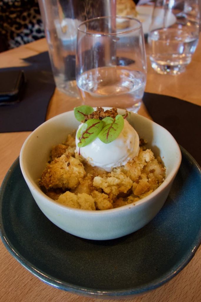 Crumble poire chocolat et glace yaourt dans un bol en terre blanc