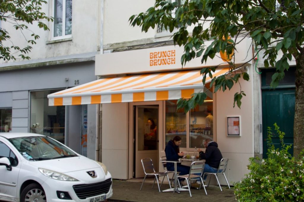 Devanture du restaurant brunch brunch avec un store ban à rayures blanches et oranges
