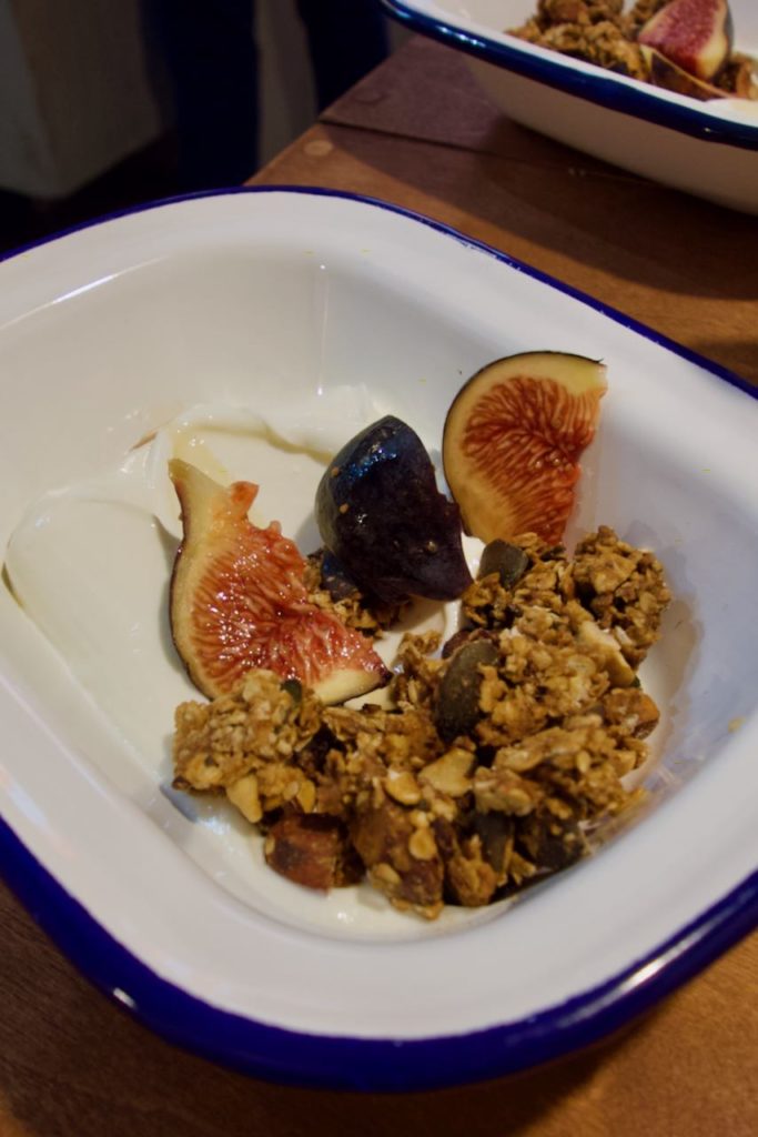 Granola, figues fraîches et fromage blanc dans une assiette creuse en métal blanc