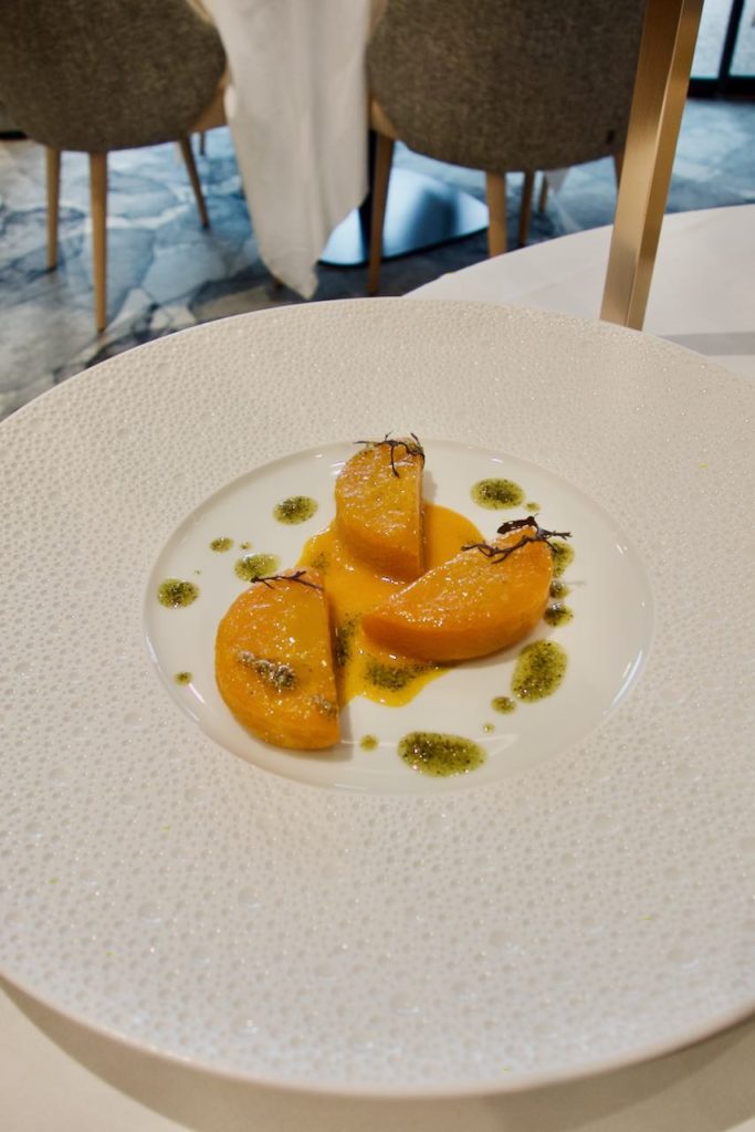Moitié de courge butternut avec des pointes de praliné graine de courge dans une large assiette blanche