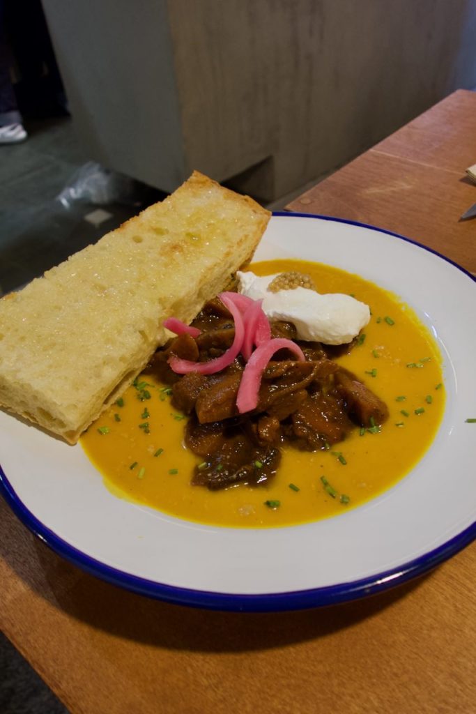 Bourguignon de légumes et focaccia dans une assiette blanche creuse
