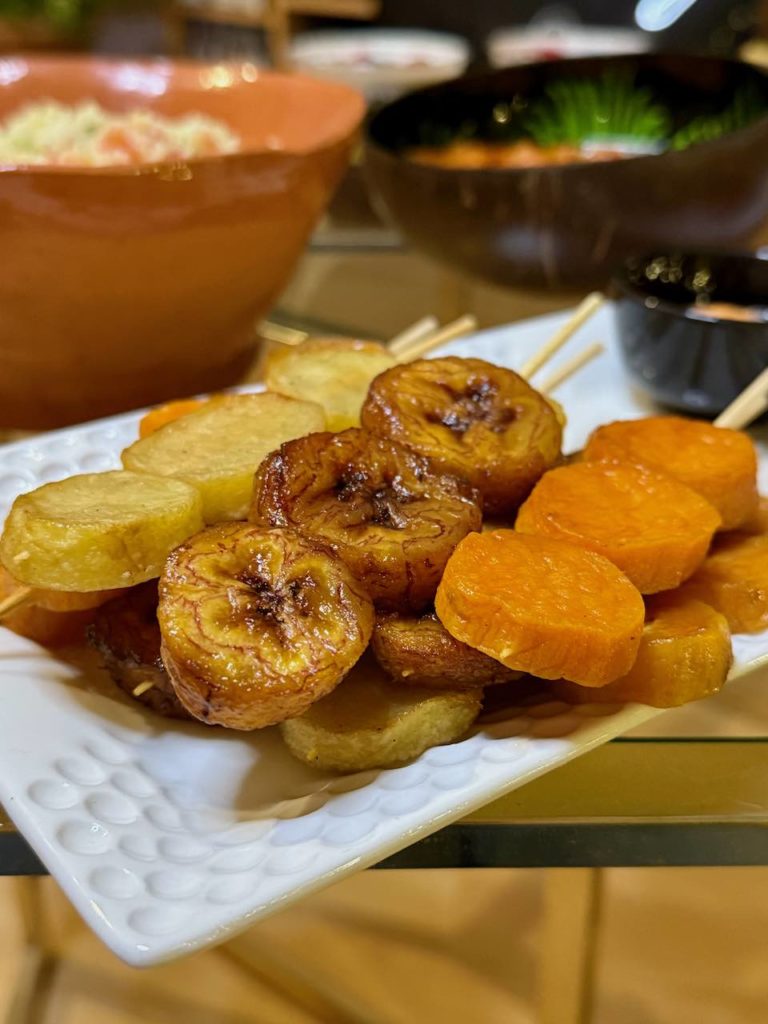 brochettes de patate douce, pomme de terre et banane plantain sur un plat blanc allongé