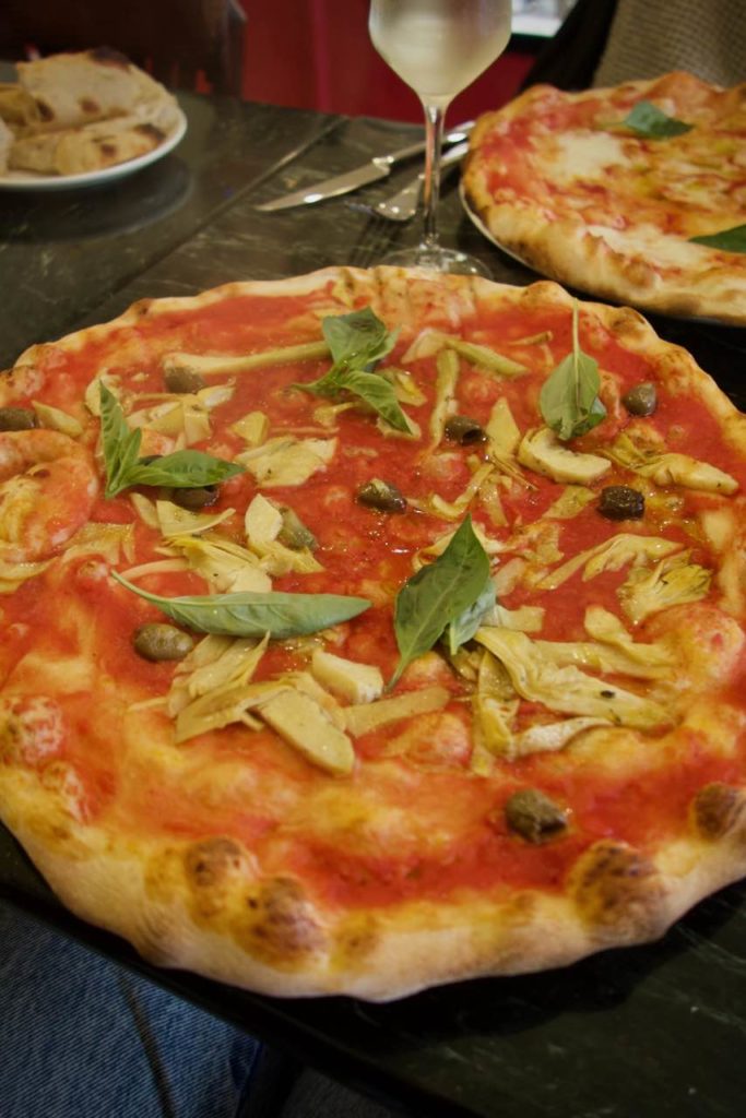 Pizza artichaut et olives avec des feuilles de basilic
