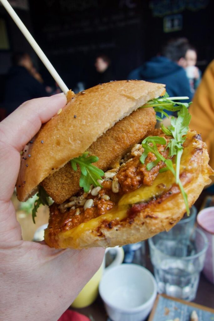 Petit burger avec du fromage pané tenu dans la main