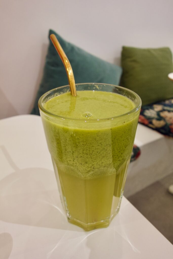 Smoothie dans un grand verre transparent avec paille en métal doré