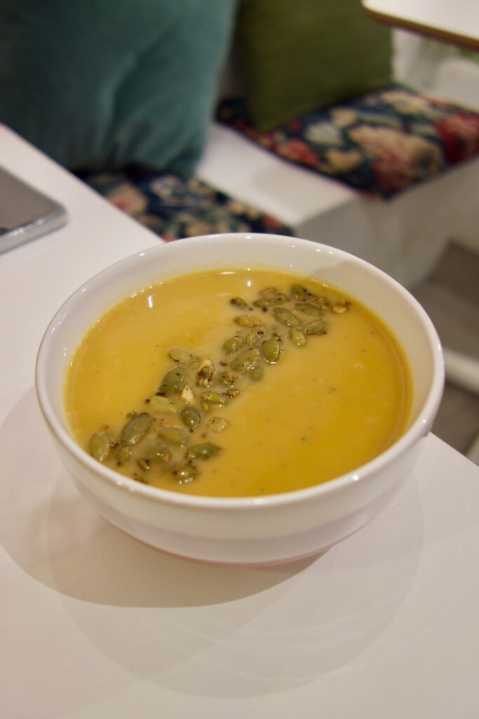 Velouté surmonté de graines de courge dans un bol blanc