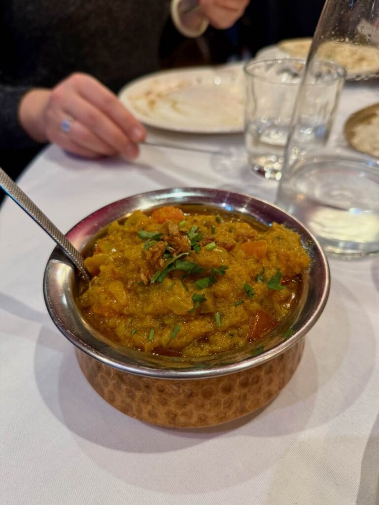 Aubergines au curry dans un bol en métal couleur cuivre