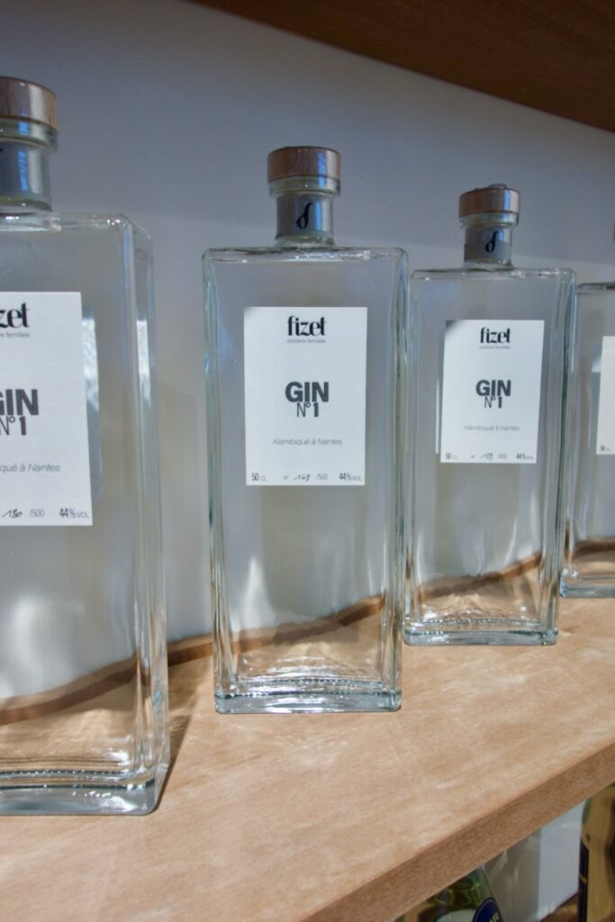 Bouteilles de Gin transparentes et rectangulaire sur une étagère en bois